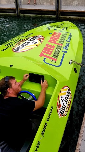 A green speedboat with a Built Strong Exteriors sponsorship logo.