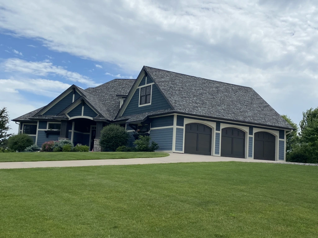 Blue Residential Home withe White and Grey Trim in Minnesota with a recent roof replacement courtesy of Built Strong Exteriors. 